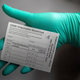 A healthcare worker displays a COVID-19 vaccine record card at the Portland Veterans Affairs Medical Center on December 16, 2020 in Portland, Oregon.